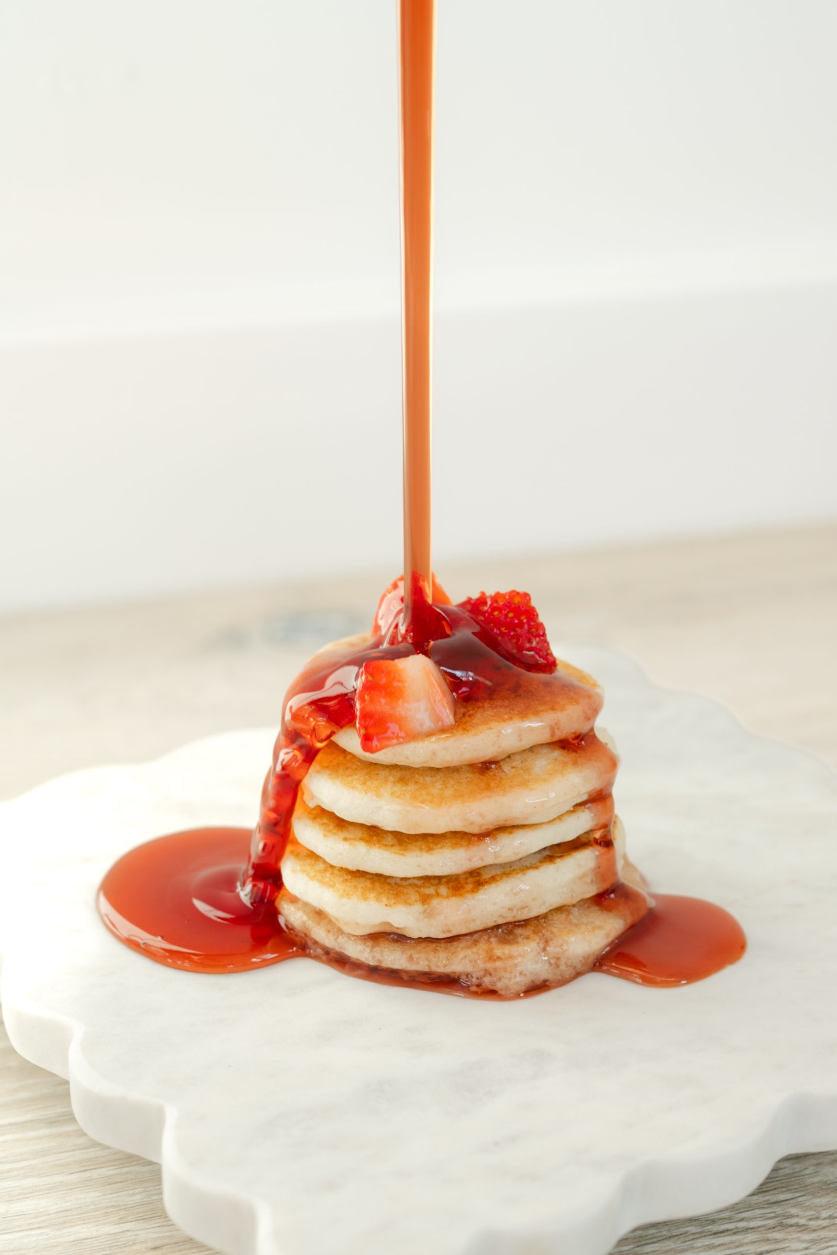 Ojai Pomegranate Syrup being poured over a stack of pancakes
